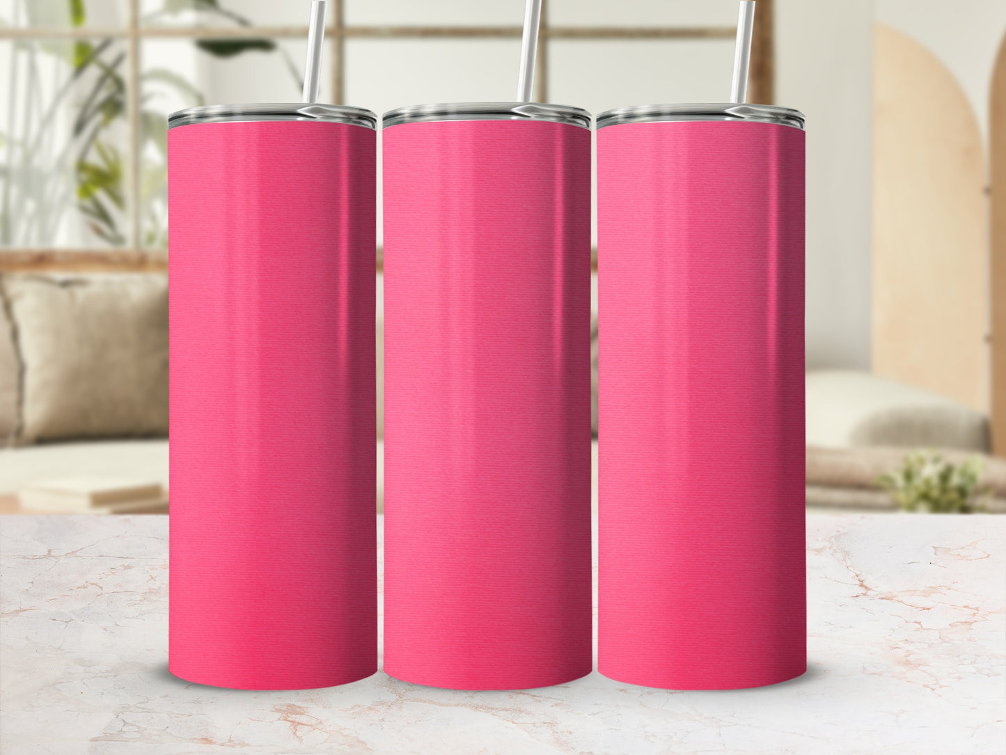 Three blank pink tumblers with straws on a marble surface.