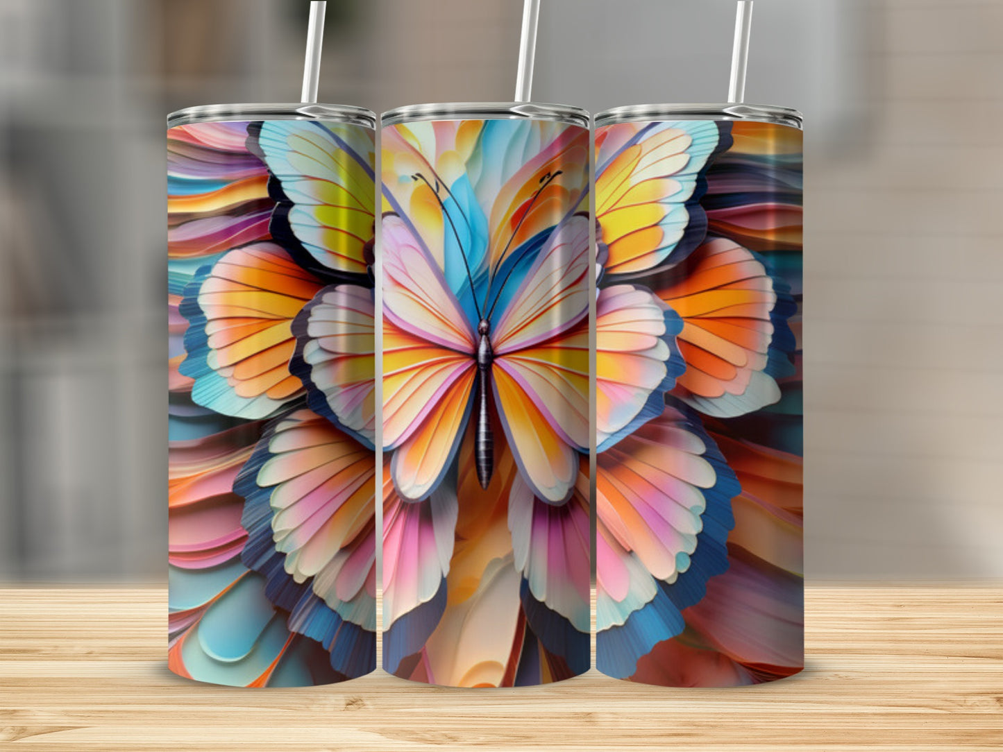 Three tumblers with vibrant butterfly wing designs sit on a wooden surface.