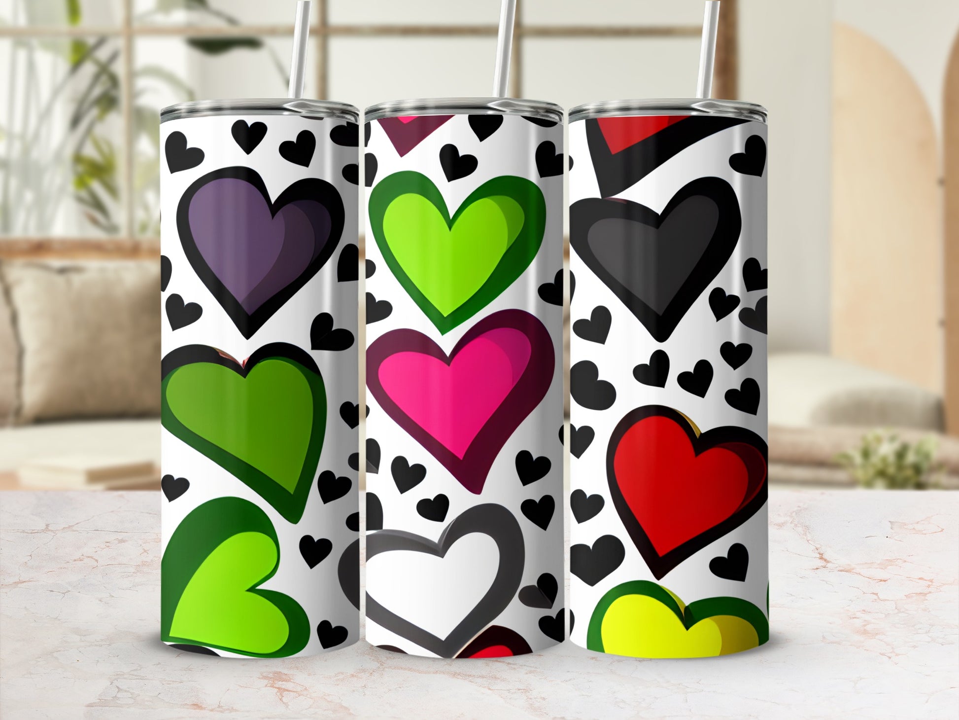 Three tumblers with colorful hearts pattern on a marble surface.