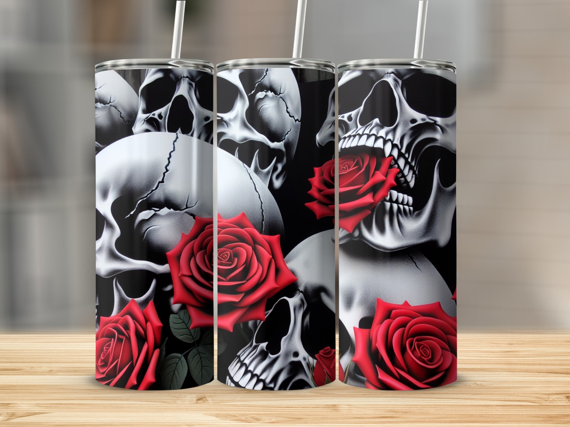 Three tumblers with skull and red rose designs displayed on a wooden surface.