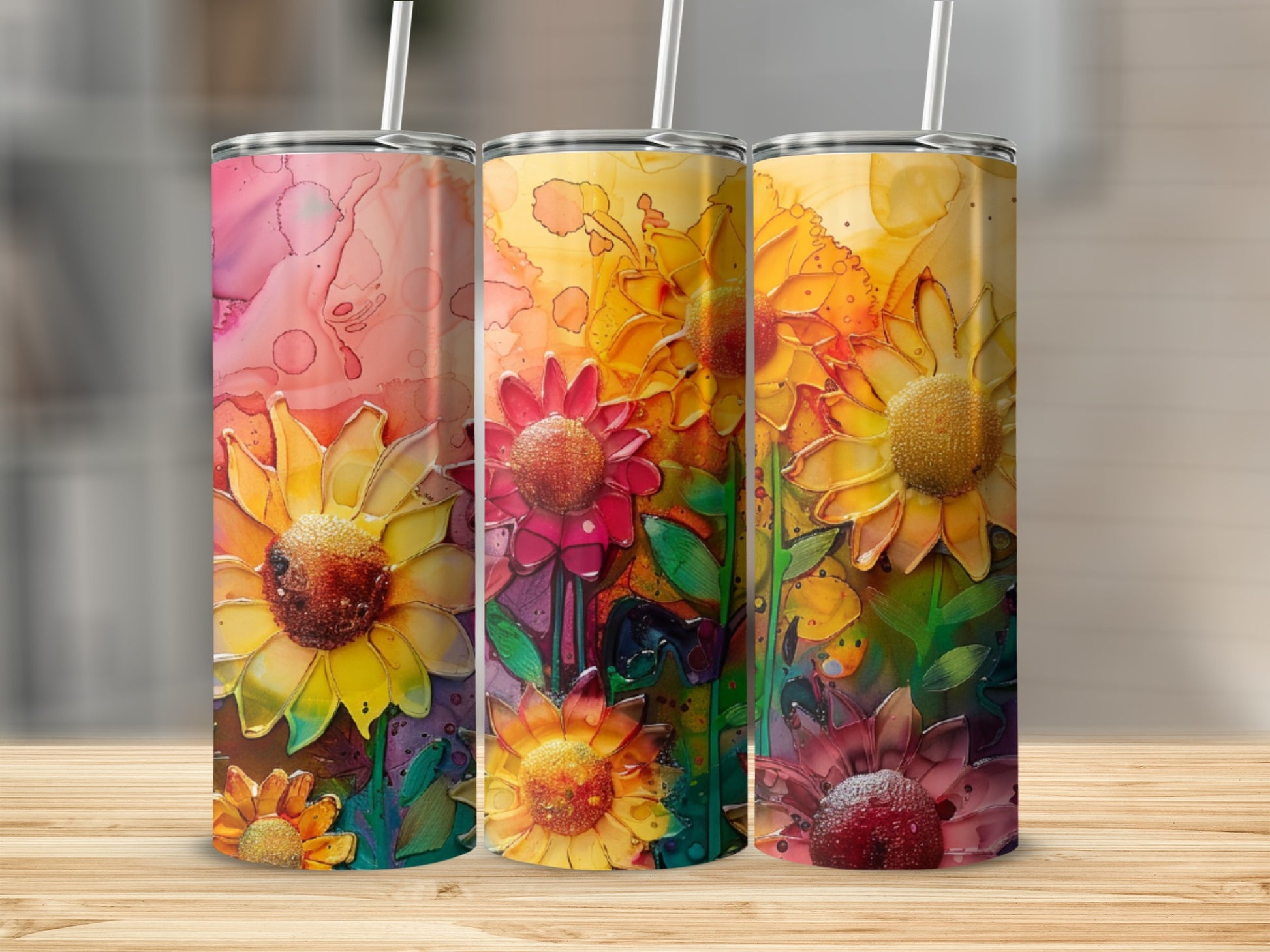 Three colorful tumblers featuring vibrant sunflower designs with abstract backgrounds.