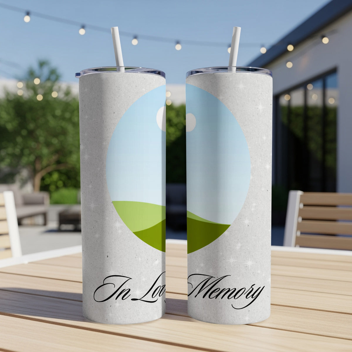 Two tumblers with "In Loving Memory" text and a landscape photo on a table.