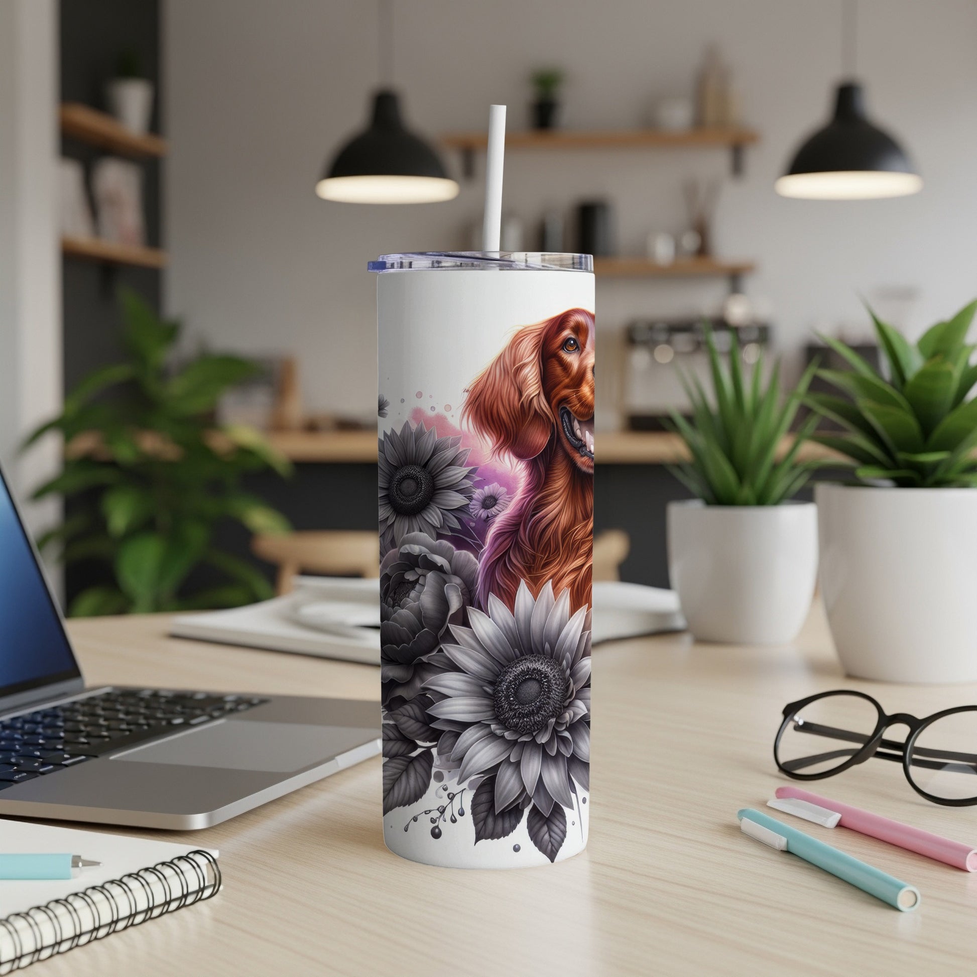 White tumbler with dog and floral design, with laptop and pens.