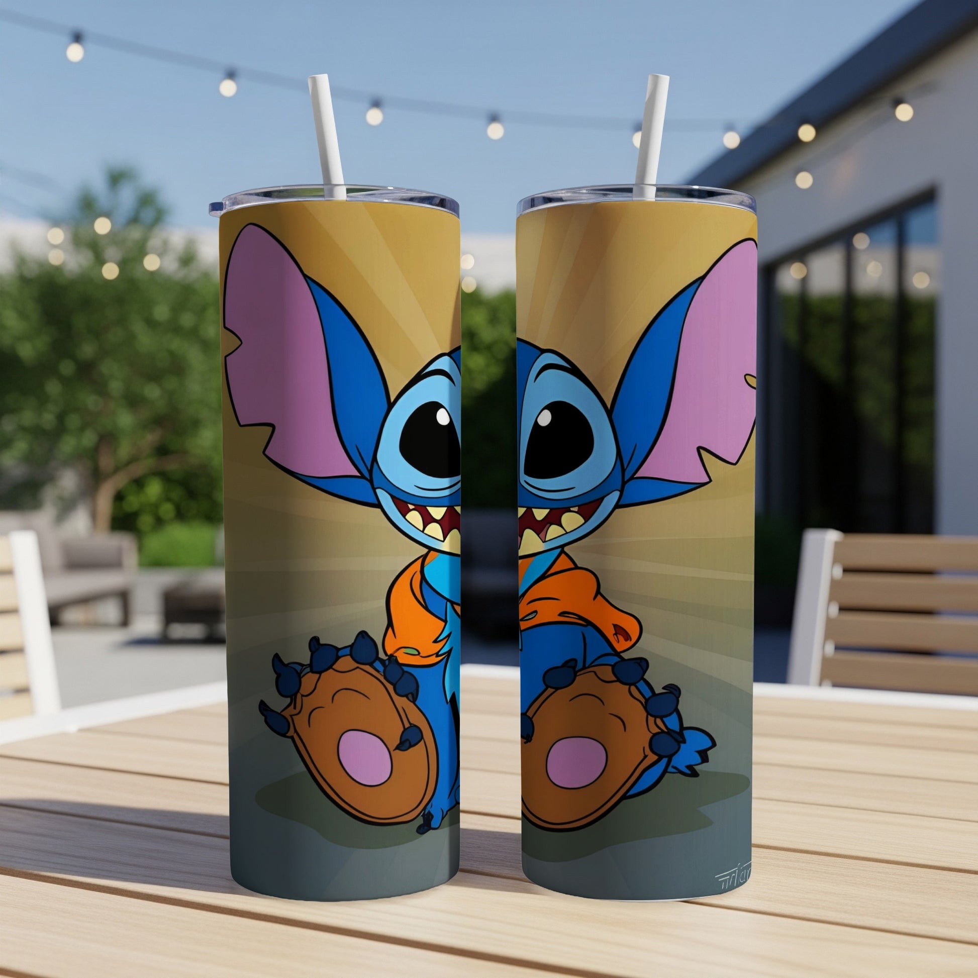 Stitch character on two skinny tumblers with straws on a table.