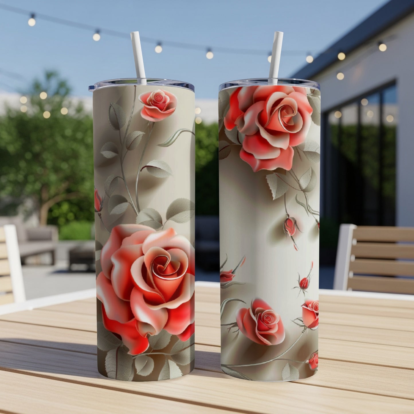 Two tall tumblers featuring a rose floral pattern on a table.