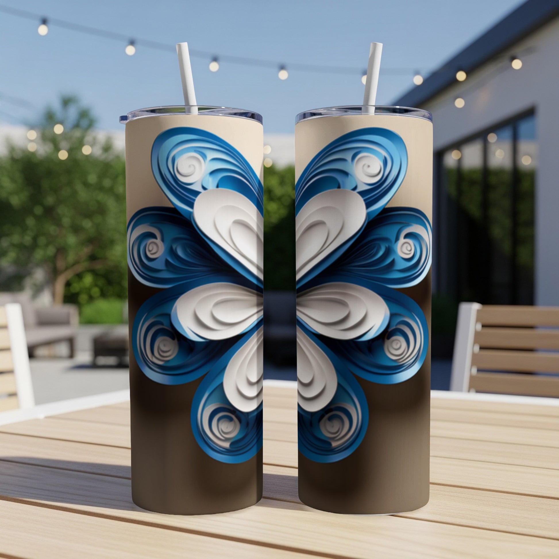 Two tall, skinny tumblers with a blue and white floral design on a table.