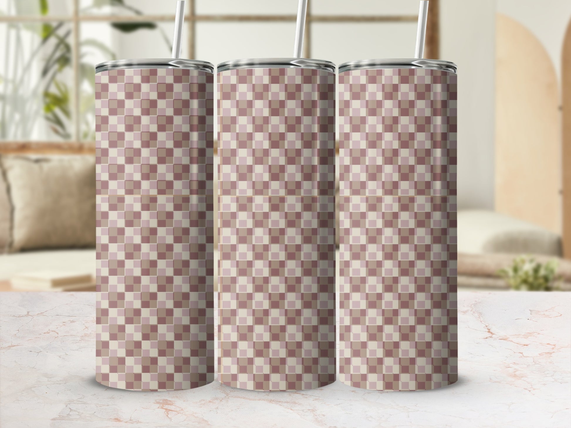 Three tall tumblers with a beige and pink checkered pattern on a marble surface.