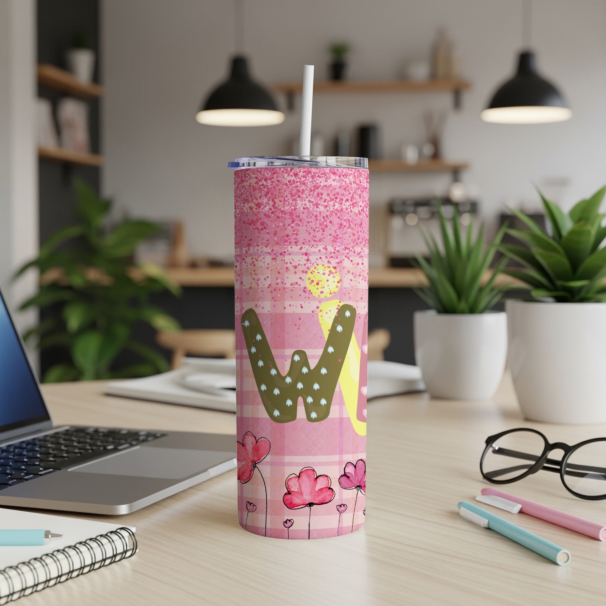 Pink tumbler with checkered pattern, flowers, and "W" design.