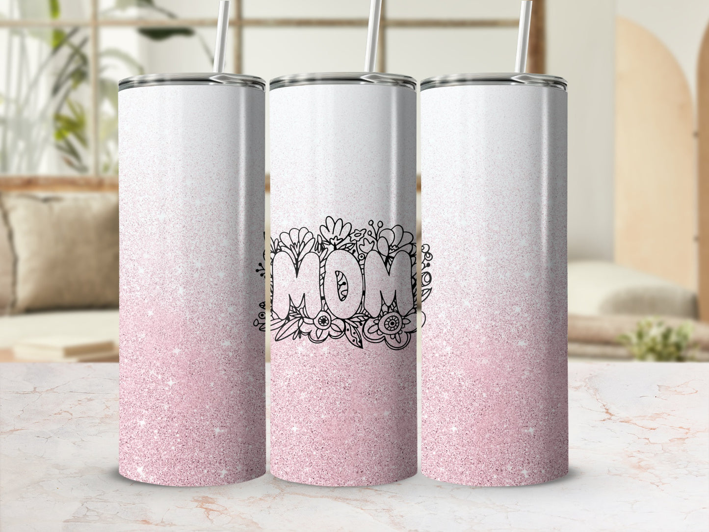 Three glitter tumblers with "Mom" text and floral design on a marble surface.