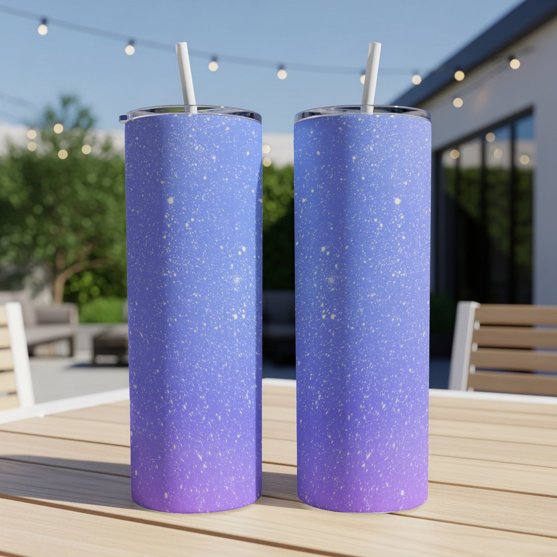 Two tall tumblers with a speckled blue and purple gradient design on a wooden table.
