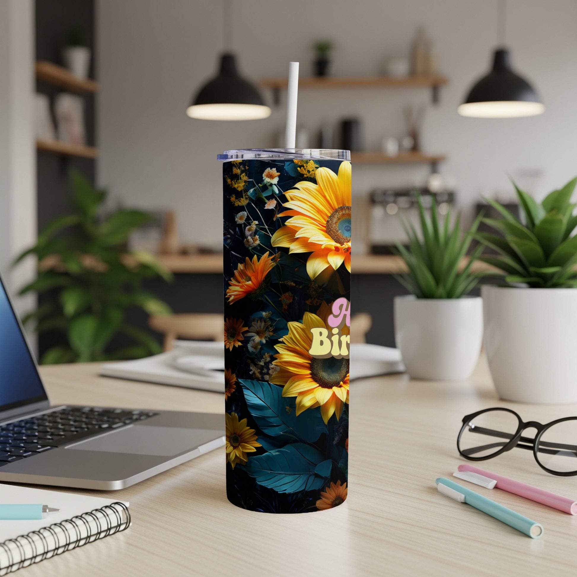 Sunflower and floral print tumbler with "Happy Birthday" text on a desk.
