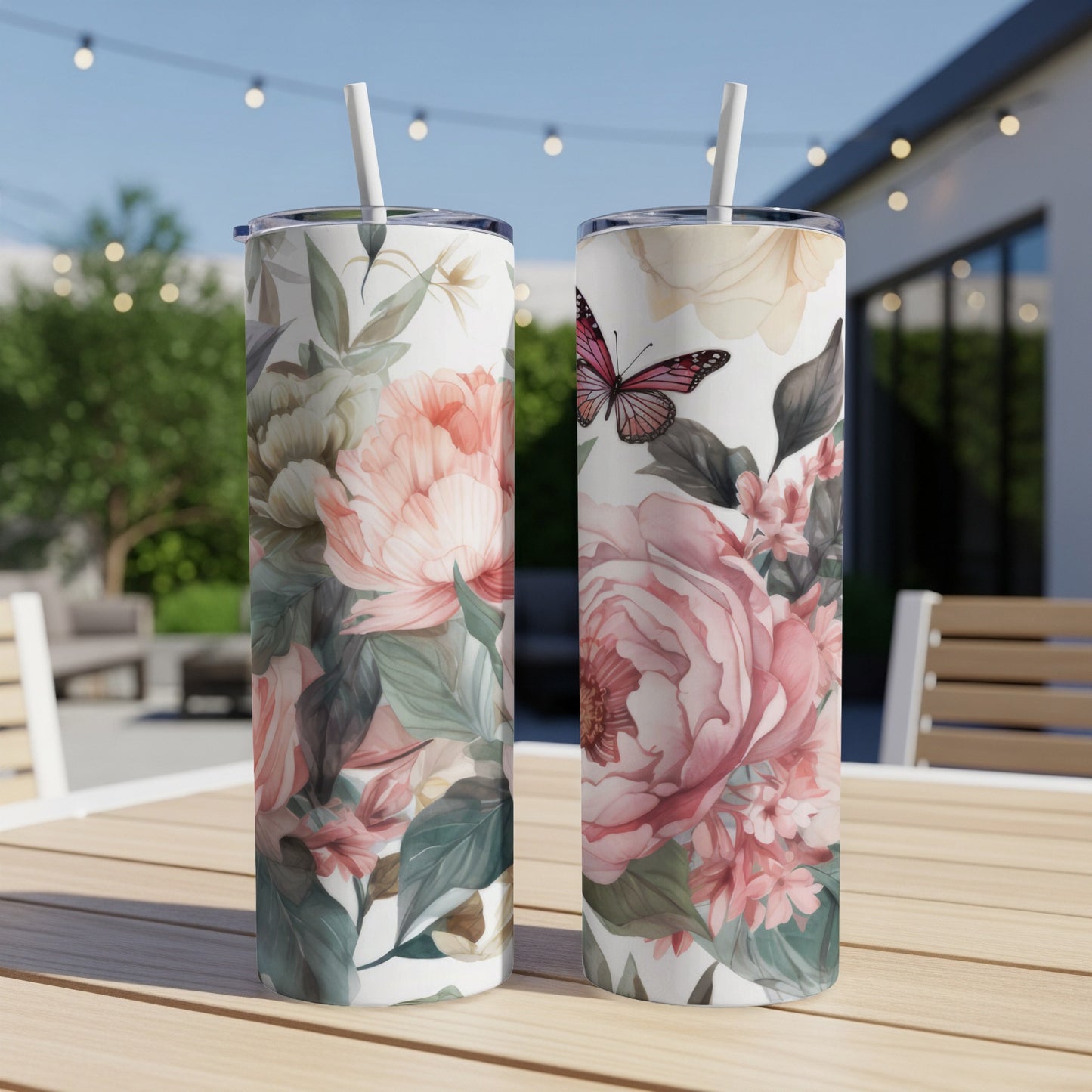 Two tumblers with floral and butterfly design on a wooden table.