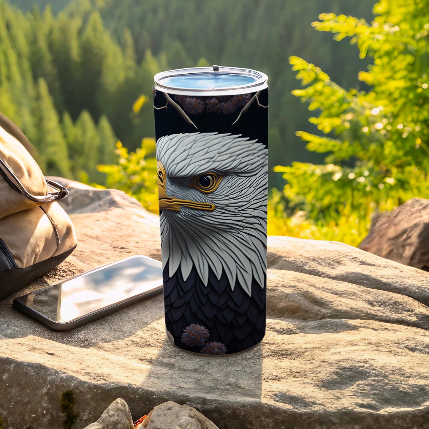 Tumbler with bald eagle portrait and dark background, resting on rocks.