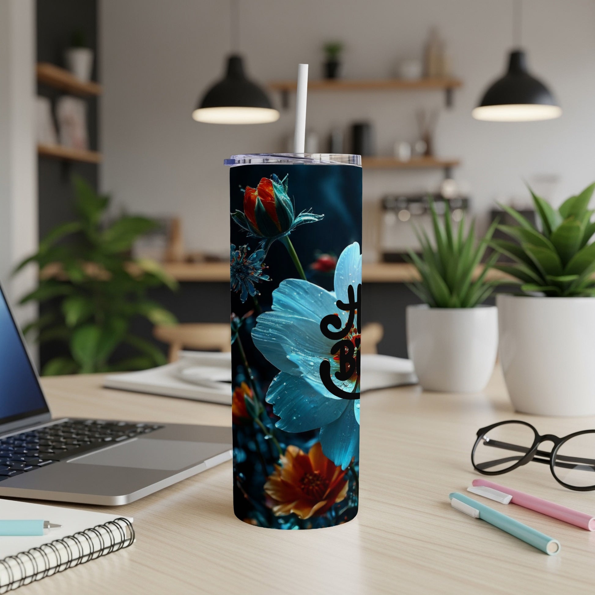 Tumbler with a white flower and "joy" text on a desk.