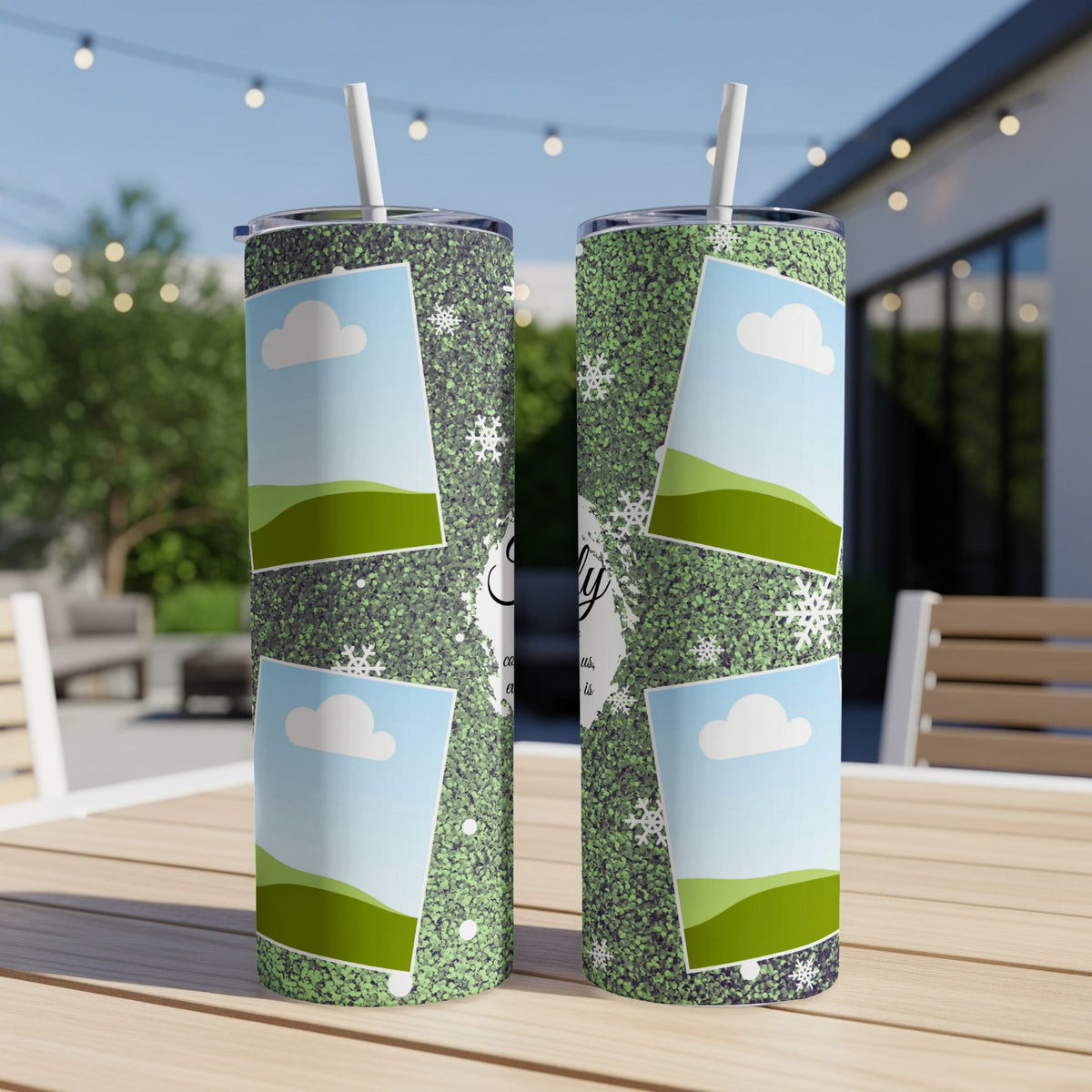 Two tumblers with a green glitter pattern, snowflakes, and photo frames on a table.