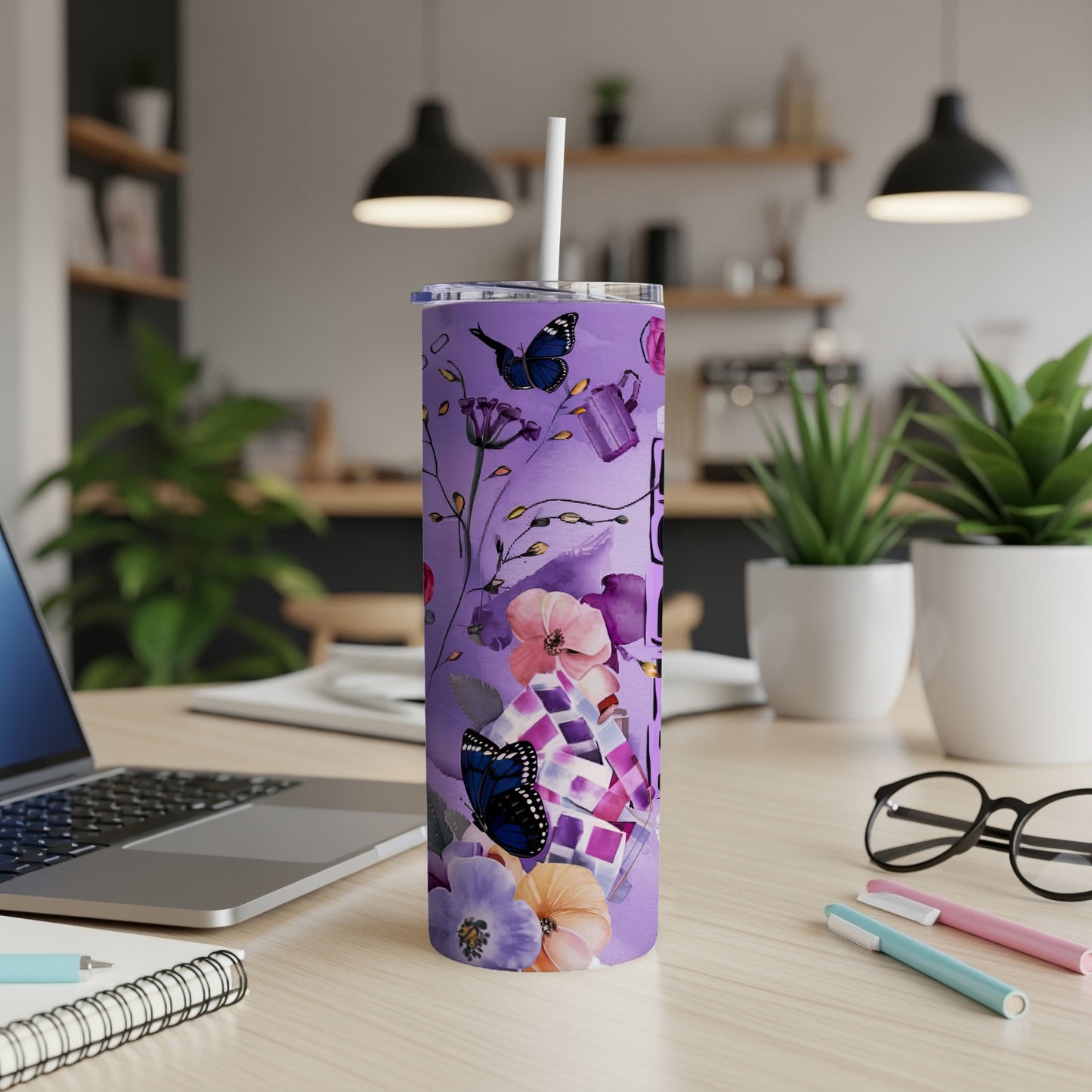 Purple floral and butterfly design on a tall, skinny tumbler with a straw.