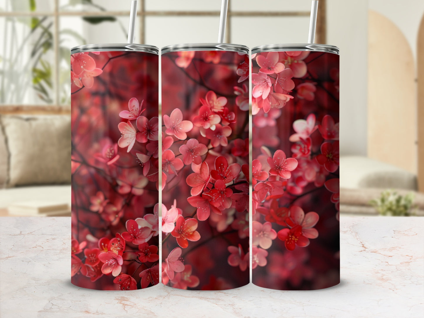 Three tumblers with a red floral pattern, set against a blurred interior background.