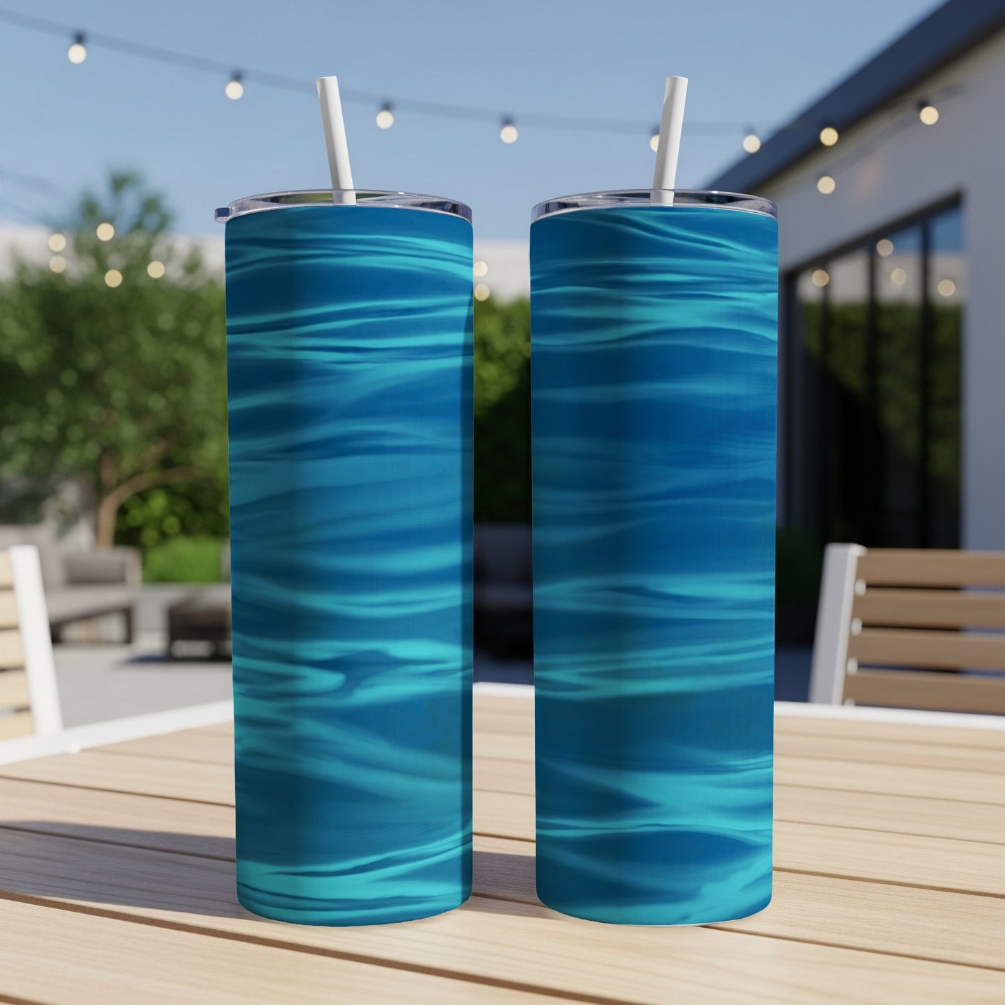 Two tall blue abstract water pattern tumblers on a wooden table.