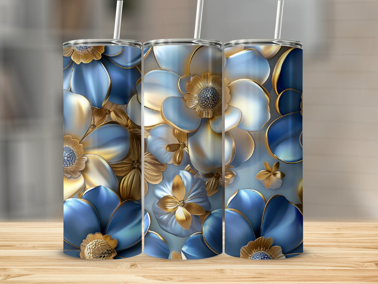 Three tumblers with blue and gold floral designs and straws.