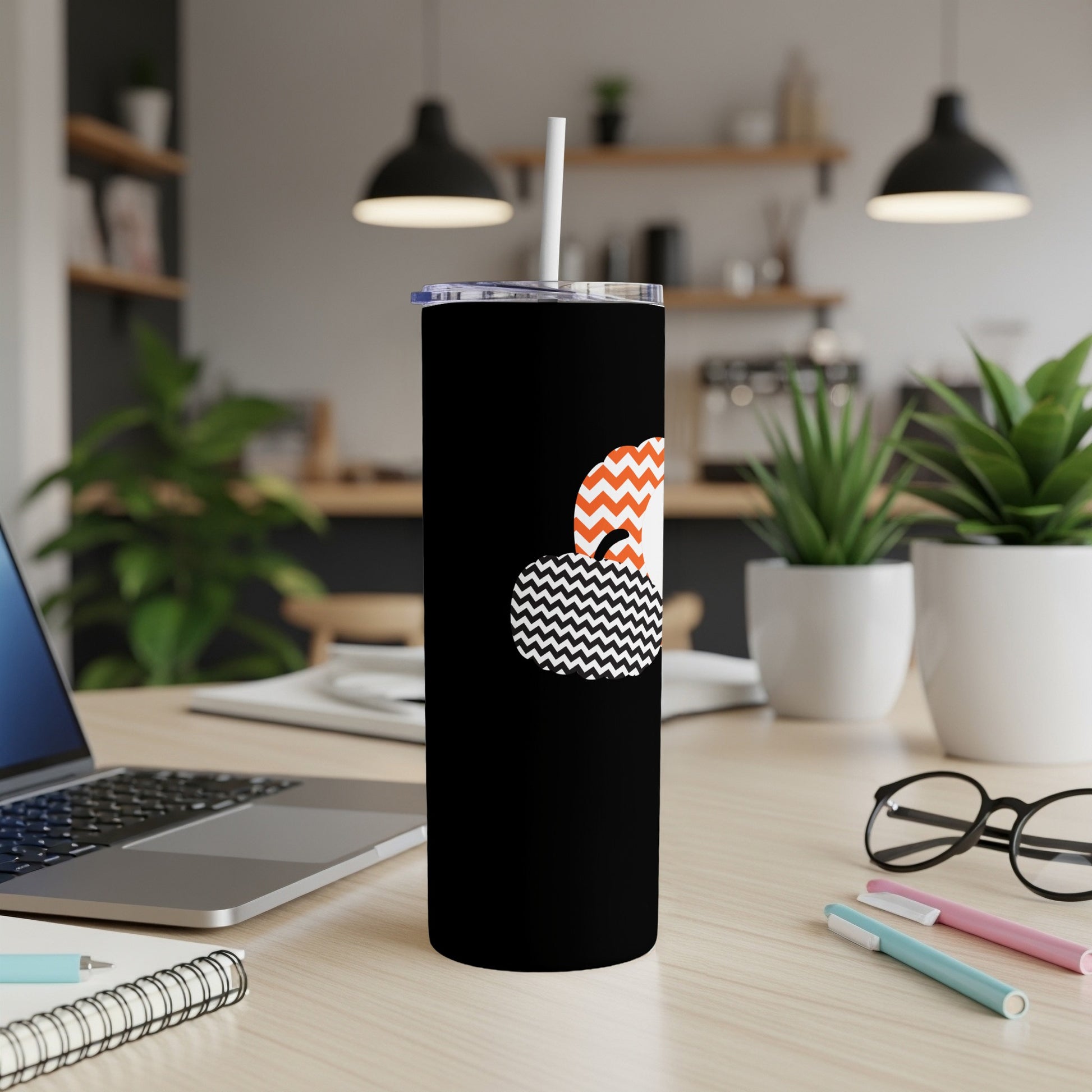 Black tumbler with orange and black zigzag and chevron pumpkin design.