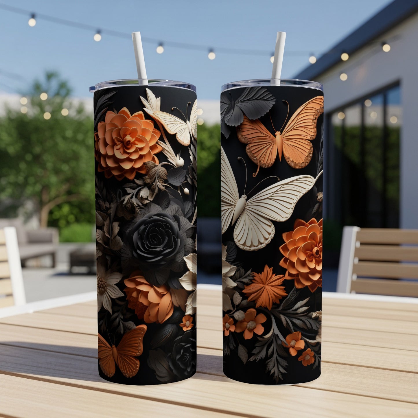 Two black tumblers with intricate floral and butterfly designs in orange and white.